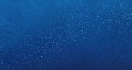 Obraz premium A deep blue background covered with densely packed shimmering particles, creating a textured surface with DOF. ideal for tech presentations, futuristic visuals, or modern digital product backgrounds.