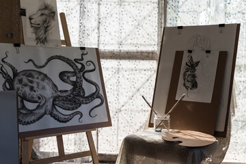 Painting animal artwork on paper board in art gallery