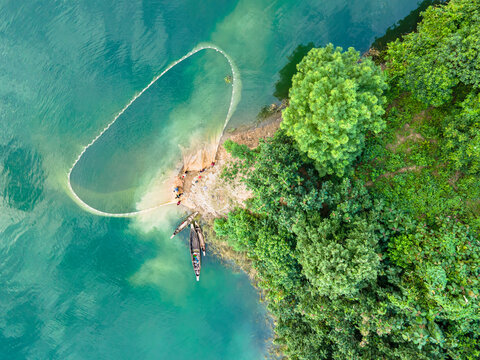 An aerial view shows local tribal people fishing with boats and big colorful nets in Kaptai Lake in Rangamati, Bangladesh, on October 22, 2024.