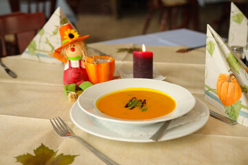 A plate of creamy pumpkin soup in a rustic restaurant