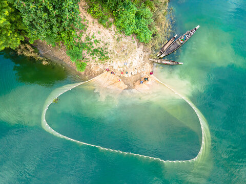 An aerial view shows local tribal people fishing with boats and big colorful nets in Kaptai Lake in Rangamati, Bangladesh, on October 22, 2024.