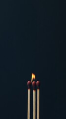 Three matches burning on dark background, leadership and uniqueness concept