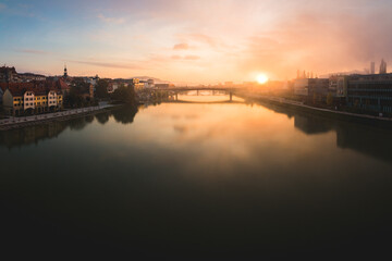 Maribor city at sunrise with fog over the river Drava. There is a bridge over the river
