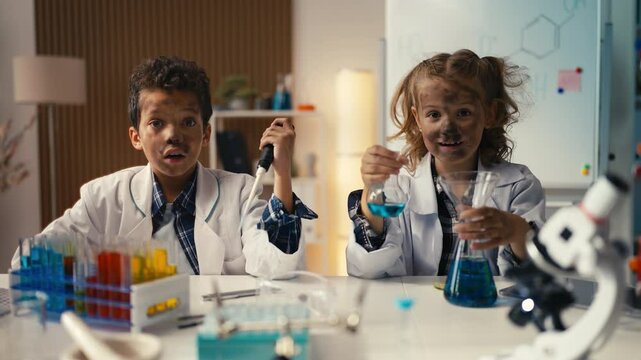Portrait of funny kids in lab coats shocked by unexpected chemical reaction