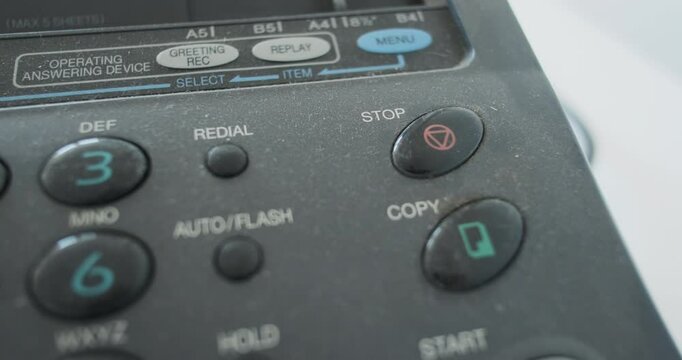 Close-up, finger pressing the stop button on an old fax machine, analog transmission of information. Concept of stop process, finish work, interrupt process