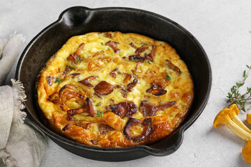 Healthy breakfast, omelette with fried seasonal forest mushrooms Chanterelles in frying pan on a light background