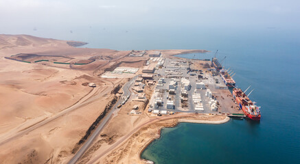 A large red ship is docked at a port, Paracas national park, Peru
