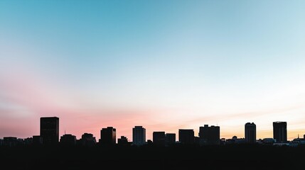 Obraz premium City skyline with a beautiful sunset in the background. The sky is a mix of blue and pink, creating a serene and peaceful atmosphere. The buildings are tall and spread out