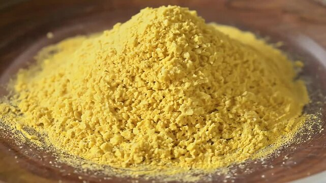 top view tartrazine food coloring powder presented wooden plate where synthetic lemon yellow azo dye CI 19140 rotates 4K video revealing vibrant hue topview additive rotation pigment