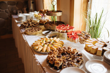 Sweets on a banquet table at a corporate party. Chocolate wafers and a dessert buffet with sweet treats. Cozy restaurant offering a variety of sweet snacks for guests.