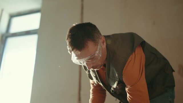 Worker using pneumatic hammer drill to cut the floor concrete brick, close up