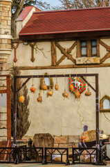 Pumpkins with a carved face, decorated with cobwebs, hung on strings against a wall, the photo better conveys the atmosphere of Halloween