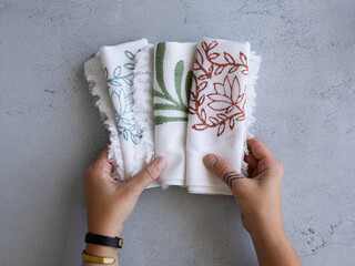 hands holding tea towels