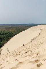 Touristes en train de marcher en file indienne sur la Dune du Pilat