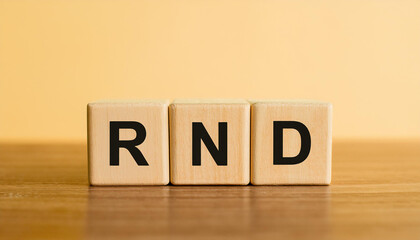 Wood cubes with abbreviation text RND on wooden table. Research and Development. Close-up.