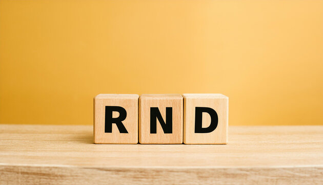 Wood cubes with abbreviation text RND on wooden table. Research and Development. Close-up.