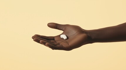 A Black man's hand is reaching out with the fingers spread open, holding an all-white pill in his palm