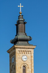 Old clock tower exterior with religious cross and brick wall pattern