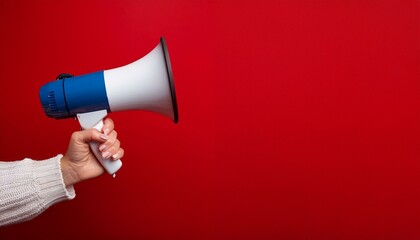 Banner discount christmas: Hand holding a megaphone announces sales and discounts, on a vibrant red background. Marketing and commercial concept banner with copy space, christmas concept