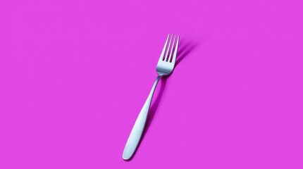 A shiny silver fork lies diagonally on a vivid neon purple backdrop, creating a bold and modern visual impact.
