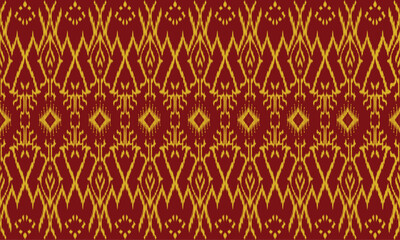 A repeating Ikat pattern in red and gold. The pattern in the image is made up of small, repeating motifs that are arranged in a symmetrical design. Ikat is a tie-dye technique.