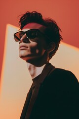 Fototapeta premium Fashion shooting man model in stylish sunglasses on minimalist background