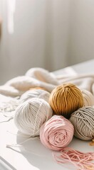 Knitting. Balls of cotton and wool yarn in warm tones on a white table. Boho, bed tones, orange, pink, turquoise, hobby