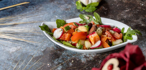 Schale gemischter salat lecker angerichtet, auf blau grauer struktur 