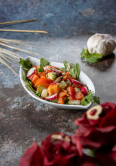 Schale gemischter salat lecker angerichtet, auf blau grauer struktur 