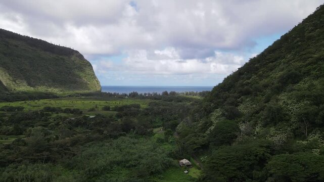 Aerial view of the Waipio Valley on the Big Island of Hawaii with its beautiful waterfalls shrouded in fog and clouds.