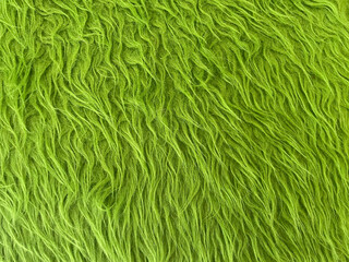 Background texture fur rug green pattern. Fluffy textile. Green carpet texture background. Close-up. Green Fabric fiber synthesis