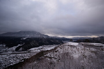 雪の積もった山と竹田城跡