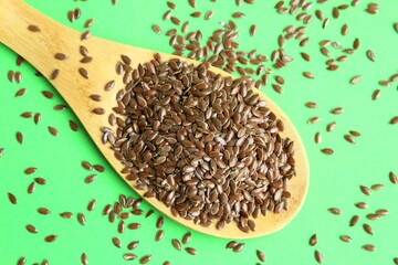 There are flax seeds in a wooden spoon.	