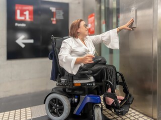 Electric Wheelchair User Pressing Elevator Button in Metro