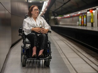 Woman in Wheelchair Waiting on Metro Platform for Train