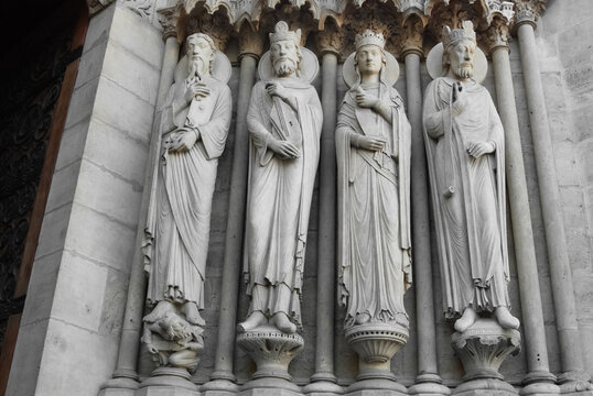 Sculpture of four ancient stone statues and details of the roof of Notre Dame Cathedral before the fire and restoration.