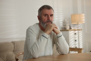 Naklejka premium Portrait of senior man at table indoors