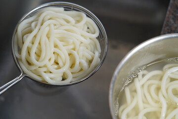 Boiled noodles in sieve, ready to eat.