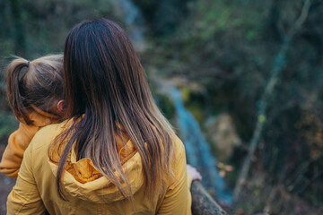 The adventurous spirit of a mother and child is depicted as they explore a serene forest, captured...