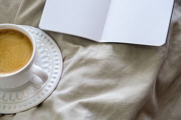 espaço livre para texto em foto minimalista superior de xícara branca com café espresso junto de página em branco sobre fundo neutro. ninguém. sem pessoas. horizontal