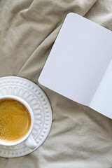 vista superior sobre fundo neutro de xícara de café e página em branco aberto sem ninguém e com espaço livre para texto. vertical. foto minimalista.