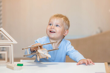 A little boy of 2 years old is playing a developing logistics constructor. Children's wooden toys....