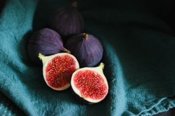 Close up of fresh ripe fig fruits in green fabric with dark shadows