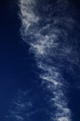 Band of thin clouds floating under a cobalt blue sky.