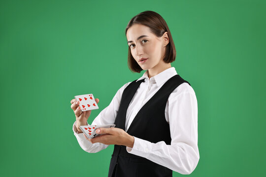 Professional croupier shuffling cards on green background