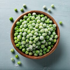 overhead view of a bowl of frozen green peas on a table