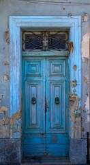 An old wooden blue door in a Mediterranean setting in a historic town in Italy.
