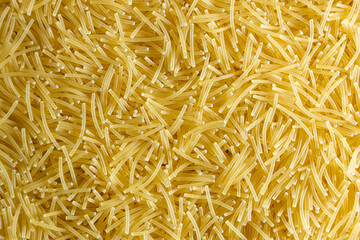 Obraz premium Uncooked Filini Pasta: A Culinary Canvas of Noodles, Creating a Lively and Textured Background for Gourmet Cooking. Dry Pasta. Raw Macaroni - Top View, Flat Lay