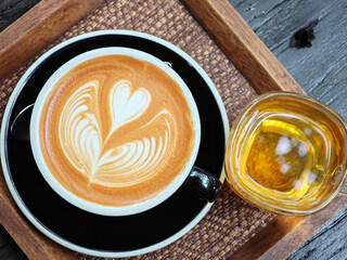 Latte art coffee served with hot tea top view
