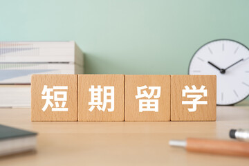 短期留学の文字が入ったブロックが置かれたデスク